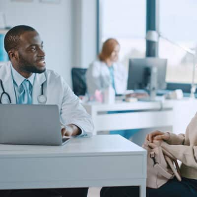 Doctor And Patient At Desk