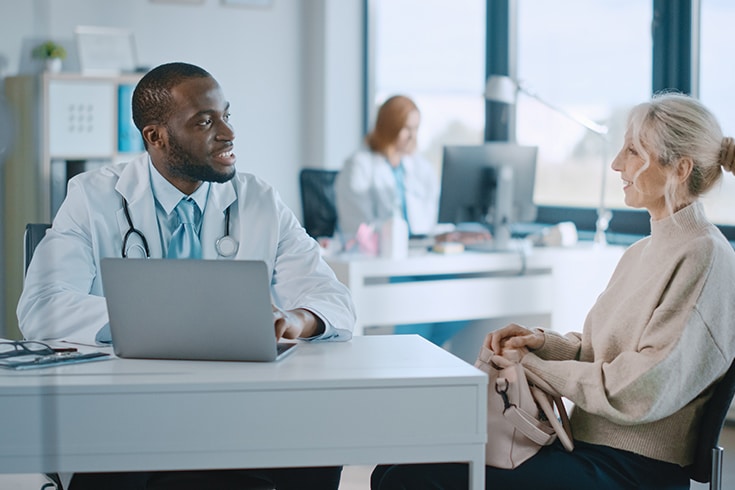 Doctor And Patient At Desk