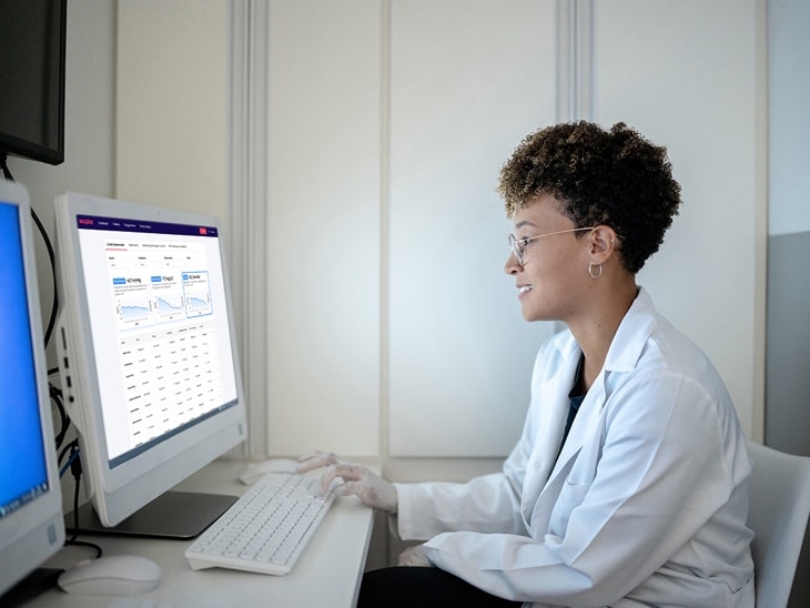 Doctor Reviewing Patient Readings at Computer