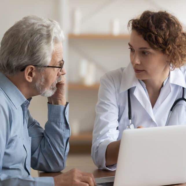 Doctor Reviewing Readings on Laptop with Patient