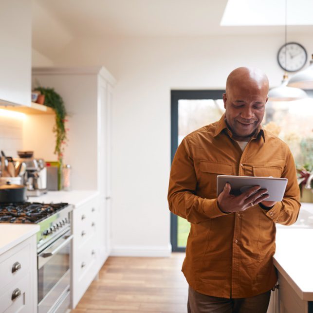 Man In Kitchen With Tablet