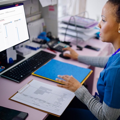 Nurse at desk monitoring patient dashboard