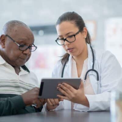 Doctor reviewing readings on tablet with patient