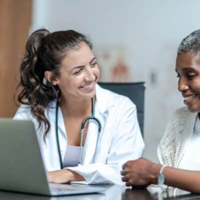 Doctor reviewing readings on laptop with patient